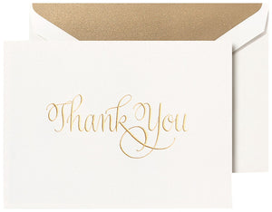 The Crane Gold Thank You Card Set features a white card with elegant gold calligraphy, paired with a matching white envelope lined in gold.