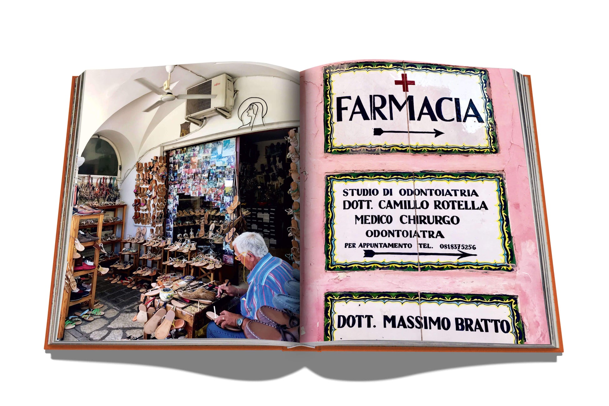 A Capri Dolce Vita book with a realistic 3d pop-up of an Italian street scene on Capri, featuring a craftsman working in a shop with signs for a pharmacy and medical offices, encapsulating the Mediterranean by Assouline.