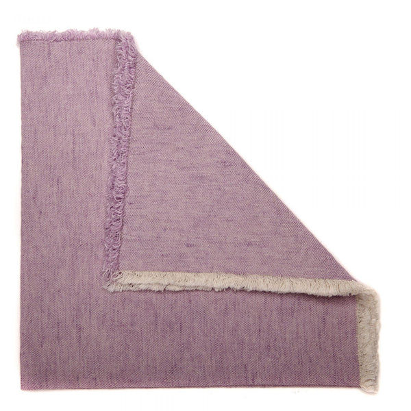 A folded Deborah Rhodes Washed Fringe Napkin, Set of 4, with frayed edges, resembling a no-iron napkin, isolated on a white background.