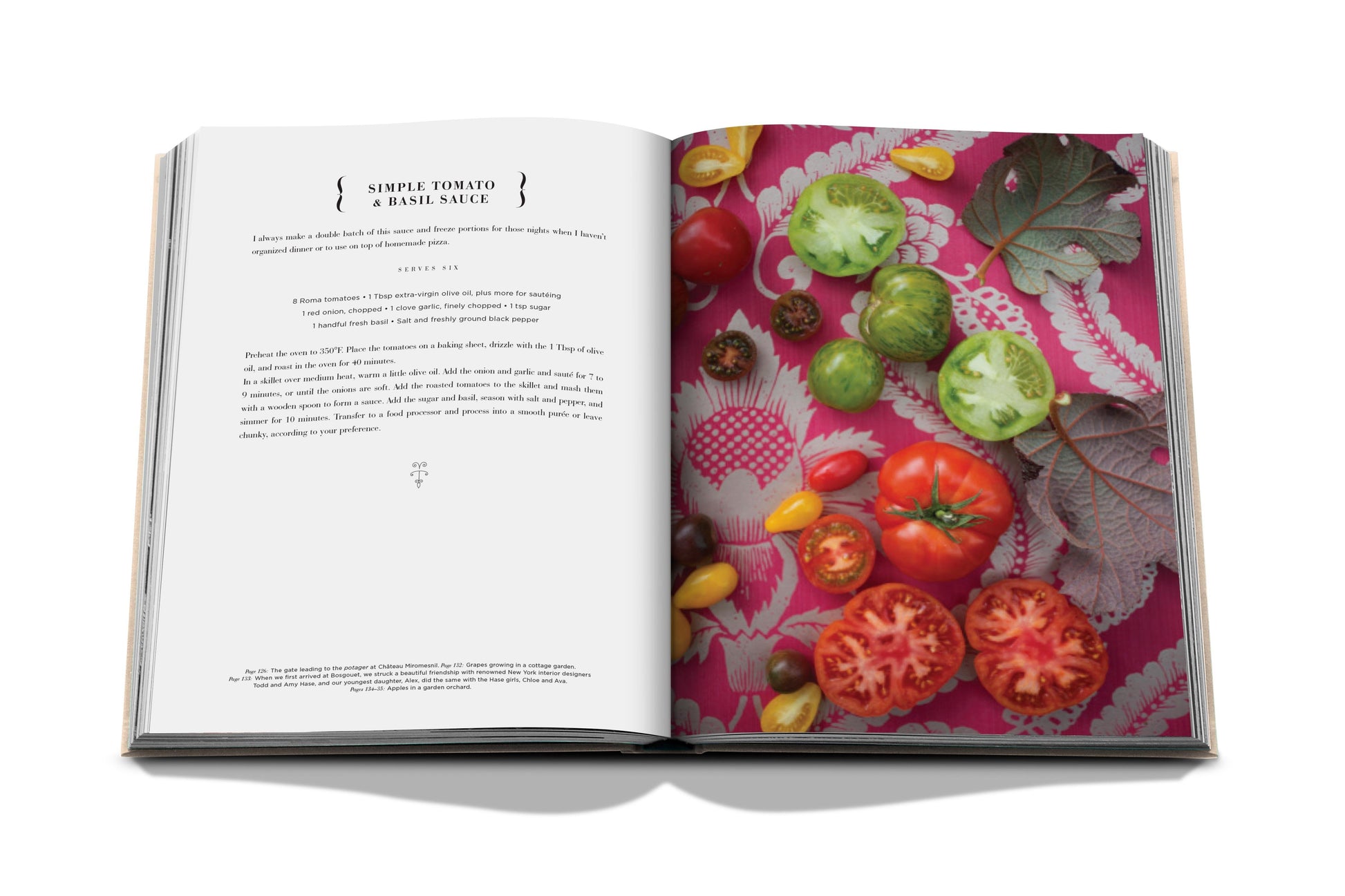 Open cookbook, titled "Chateau Life" by Assouline, displaying a recipe for simple tomato and basil sauce on the left page, with various ripe tomatoes and basil leaves artfully arranged on a colorful tablecloth on the right page, evoking rich culinary traditions.