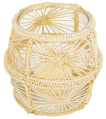 A Mercedes Salazar Raffia Candle Holder with a candle inside.