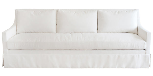 A white Hannah Sofa with a ruffled skirt, featuring Verellen upholstery.