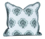 The Artichoke in Bay Pillow by Hive Custom Pillows features a square shape, white background, blue-green patterned design, and fringed trim.