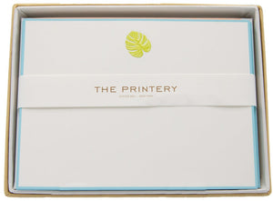 The Palm Leaf Card Set by Printery features bright white cards with a gold palm leaf design and Printery branding, neatly arranged in a box and wrapped with a white band.