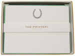 The Printery Horseshoe Card Set includes silver horseshoe cards with a green square corner on the top card, paired with black tissue envelopes and finished with a branded band.