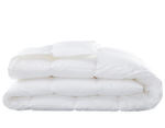 The Matouk Libero Hypoallergenic Comforter Summer Weight, in white with down-free fill, is neatly folded and stacked on a plain background.