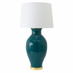 The Matagorda Glossy Mallard Lamp by Paul Schneider Ceramics features a glossy dark teal ceramic base with a gold accent, dimmer socket for adjustable lighting, and a white fabric shade.