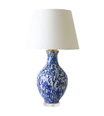 The Athens Lamp in Dappled Blue & Celadon by Paul Schneider Ceramics features a white and blue patterned ceramic base, a plain white lampshade, and a stylish lucite base, displayed against a white backdrop.