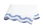 A folded white bedsheet with a light blue scalloped edge, crafted from 600 thread count Egyptian cotton percale—an elegant piece from the Matouk Mirasol Bedding Collection, Azure.