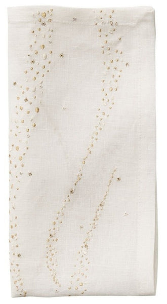 A Star Spray Napkin White/Gold/Silver by Kim Seybert with decorative gold sequin embellishments arranged in a cascading pattern.