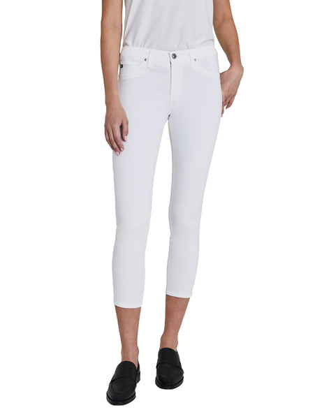 A person standing in white AG Jeans Prima Crop Luscious Super Stretch Sateen cigarette pants and black shoes against a white background.