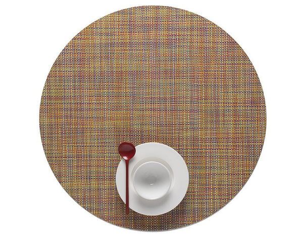 A Chilewich Round Placemat, Confetti, adorned with a spoon and fork, perfect for a dining occasion in the USA.