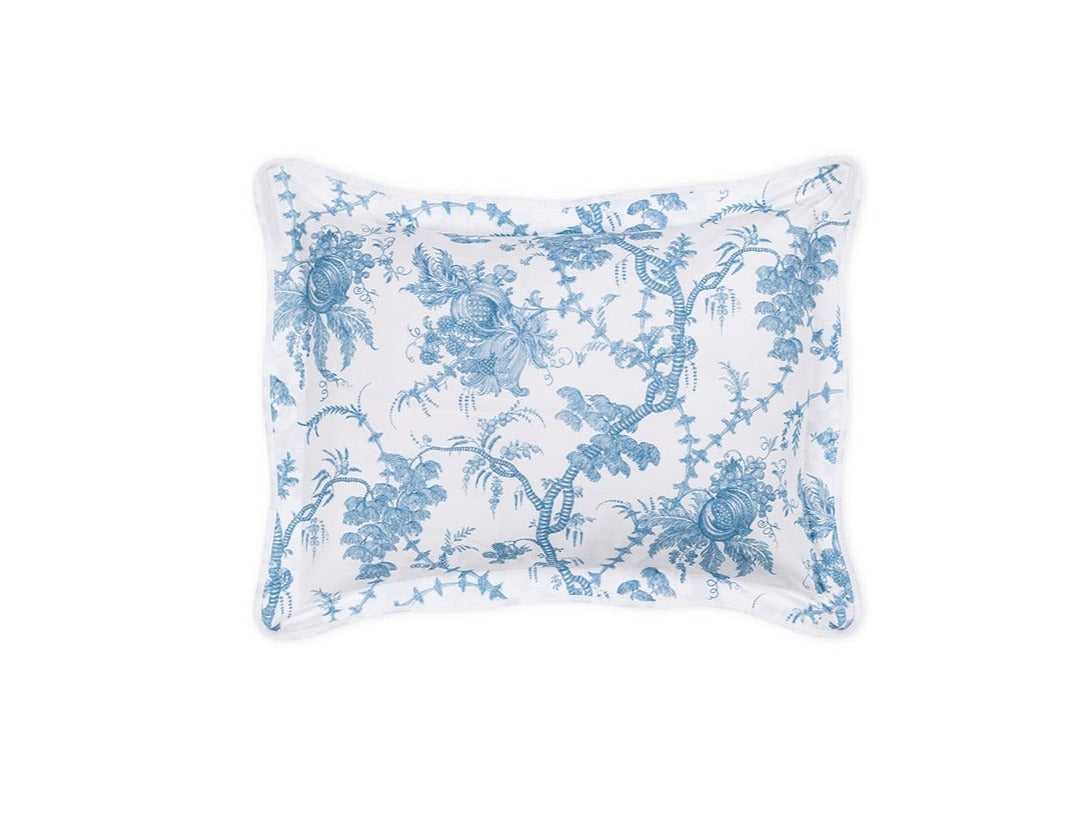 The Matouk San Cristobal Bedding Collection, Sky, features a rectangular pillow with blue floral and vine patterns on white Luca Egyptian cotton percale, slightly curved edges, a thin border, and OEKO-TEX® Standard 100 certification.