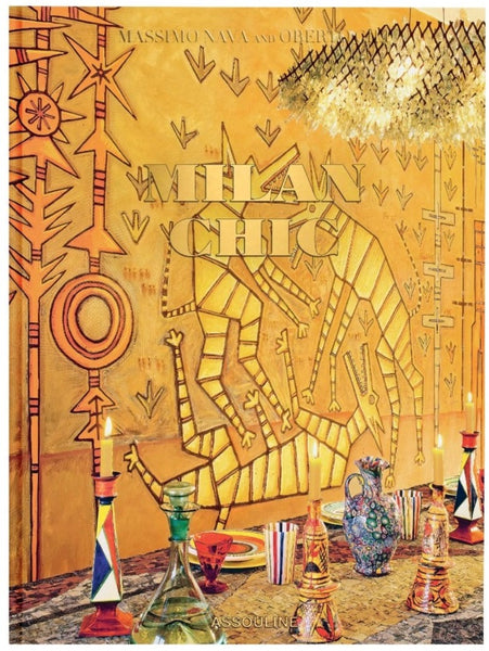 An ornately set table with colorful glassware in front of a tapestry with abstract designs and the text "Assouline Chic.