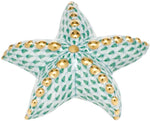 The Herend Puffy Starfish is a porcelain figurine with a green scale pattern and gold accents, inspired by hand-painted designs and displayed against a white background.