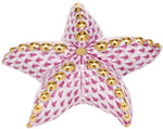 The Herend Puffy Starfish figurine features a pink fishnet pattern, hand-painted designs, and gold-colored raised dots on each arm, inspired by classic Herend porcelain.