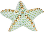 The Herend Puffy Starfish is a decorative ceramic piece featuring a green scale pattern and gold accents on each arm, inspired by classic Herend porcelain and shown on a white background.