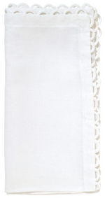 The Loop Edge White Napkin Set by Kim Seybert features neatly folded linen napkins with delicate scalloped detailing, ideal for enhancing your tabletop setting.