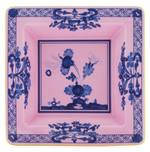 The Oriente Italiano Azalea with Gold Vide Poche by Ginori 1735 is a square pink plate featuring blue floral and geometric patterns, radiating Far Eastern charm and exotic beauty.