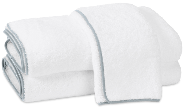 Two white fluffy Matouk Cairo Bath Collection - Pool towels made from OEKO-TEX® Standard 100 certified plush cotton terry, neatly folded and stacked.