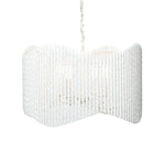 The Camille Chandelier by Made Goods features a white, wavy cylindrical shade made of vertically twisted plaster bars, suspended by a chain against a plain background.