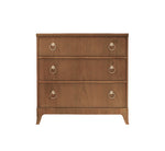 The Single Chest by Kindel is a wooden dresser made from cherry hardwood, featuring three drawers with metal ring pulls and short legs. Front view presented.