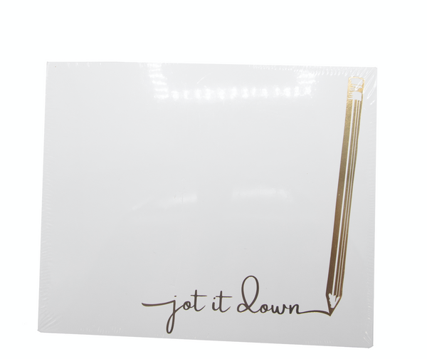 A Black Ink large notepad with a gold pencil lay on top.