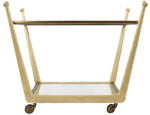 The Rosa Trolley Cart in Bleached Oak, crafted by Julian Chichester, features a glass top and bottom shelf, angled legs, and four brass castors for easy mobility.