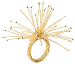 The Kim Seybert Spider Bead Burst Champagne Napkin Ring features an intricate burst design with radiating beaded spikes, adding a touch of elegance to your table setting.