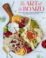 A charcuterie board artfully arranged with an assortment of cheeses, crackers, fruits, nuts, and meats on a wooden board. The cover text reads "The Art of the Board: Elevate Your Snack Boards" by Olivia Carney from Common Ground.