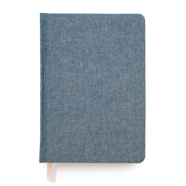 A Tailored Chambray Journal by Sugar Paper on a white surface.