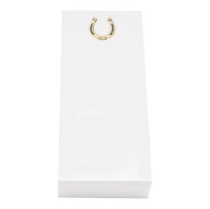 The Horseshoe Skinny Notepad by Black Ink comes in a white rectangular box made of smooth cardstock, accented with a gold horseshoe-shaped detail near the top center, evoking the look of elegant gold foil notepads.
