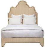 Ingrid Raffia Bed, King by Oly, with an ornate headboard featuring nailhead detail, dressed in white sheets and pillows.