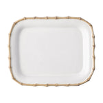The Juliska Classic Bamboo Small Rectangular Platter is a white ceramic stoneware plate with a raised edge and gold bamboo-style border, adding an exotic touch to any setting. Photographed on a white background.