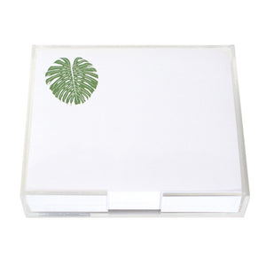 The Black Ink Monstera Leaf Large Notepad features luxurious white note paper with a green monstera leaf illustration in the top left corner, held in a clear Lucite holder measuring 8.5" x 7".