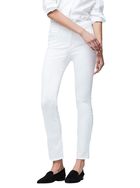 A woman wearing Frame Le High Straight white jeans and a white shirt paired with black loafers, standing against a plain background, with her left hand resting on her hip.