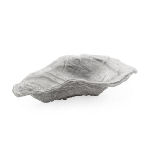 The Michael Aram Ocean Reef Oyster Shell Bowl features a shallow, irregular shape with a rough, stone-like gray finish, inspired by natural rocks or shells near coral reefs.