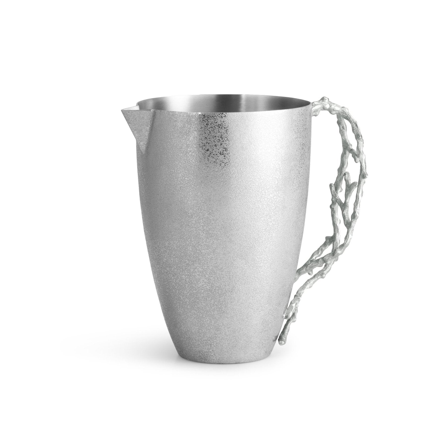 The Ocean Reef Pitcher by Michael Aram features hand-textured stainless steel with a matte finish and a sculpted, branch-like handle, showcasing intricate beauty against a white background.