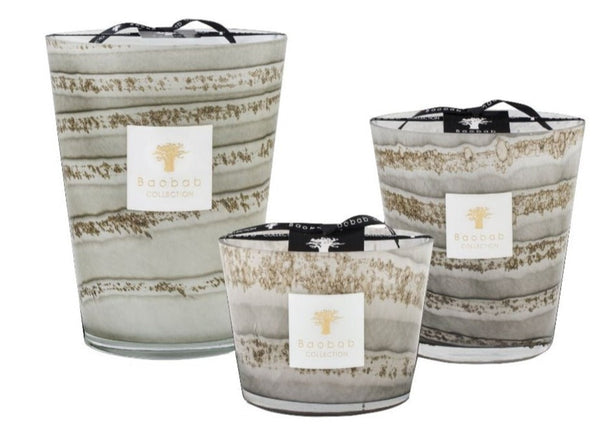 Three Earl Grey Tea scented Baobab Sand Atacama Candle Collection candles of varying sizes with a beige, brown, and white patterned design on the exterior and black logo tags attached to the front.