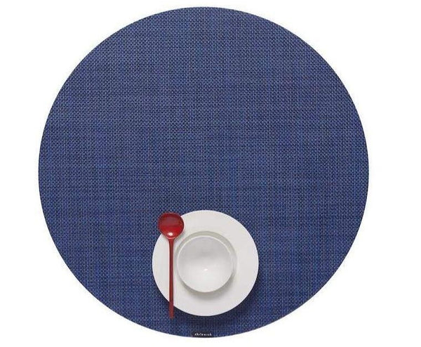 A blue Chilewich Round Placemat in Indigo with a spoon and fork on it is perfect for any dining occasion.