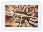 A tennis team in white shoes and socks forms a circle on the court with vintage rackets, captured in Gray Malin’s "The Tennis Team Coral Beach Club," White Frame, 29.5" x 41.5".