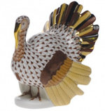 The Herend Turkey Collection features a handmade porcelain turkey figurine with a patterned brown and white body, brown wings, gold and yellow tail feathers, and delicate 24K gold accents.
