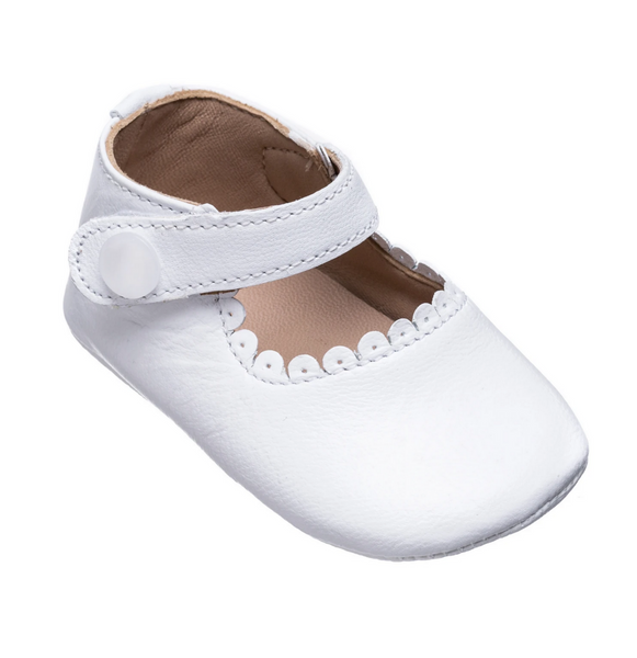 A handmade white leather baby shoe with a buckle, resembling Elephantito's Elephantito Baby Mary Janes.