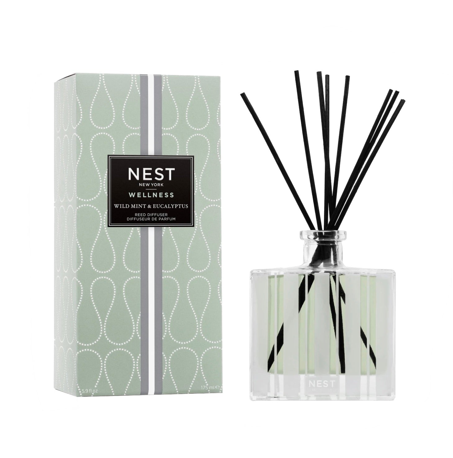 The Nest Wild Mint & Eucalyptus Reed Diffuser features fragrance oils in a clear glass bottle with black reeds and comes boxed in a green pattern, ideal for refreshing your space.