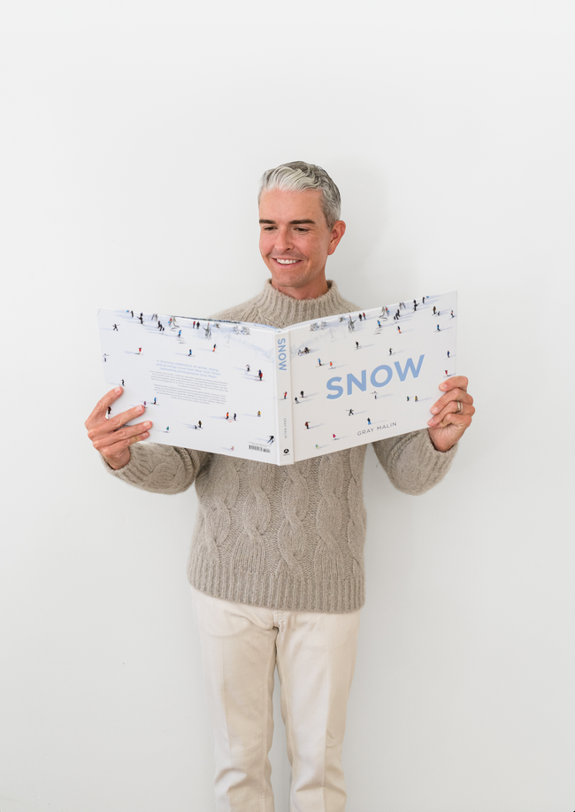 Gray Malin reading book titled Snow