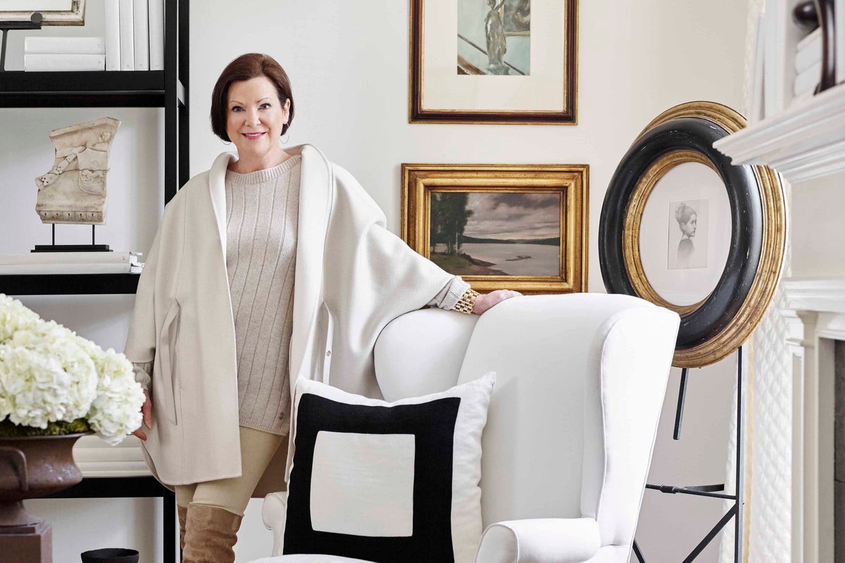Image of Beth Webb standing by a white chair