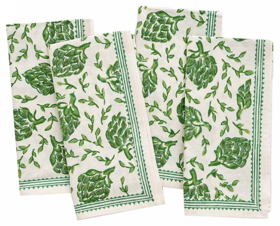 Four folded white cloth napkins from the Pomegranate Inc. Dancing Artichokes Collection, featuring a green and white print of hand-painted globe artichokes and leaf patterns, are arranged in a staggered layout.