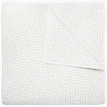 A white coverlet from the Hand-Stitched Bedding Collection by John Robshaw, featuring a subtle stitched pattern and organic cotton, is neatly folded with one corner turned down to reveal its detailed texture.