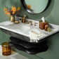 The Benton Tortoise Bath Collection by Pigeon & Poodle adds elegance with tortoiseshell accents, while gold fixtures, a marble countertop, orange flowers in a gold vase, and a round mirror enhance the modern bathroom against a green wall.