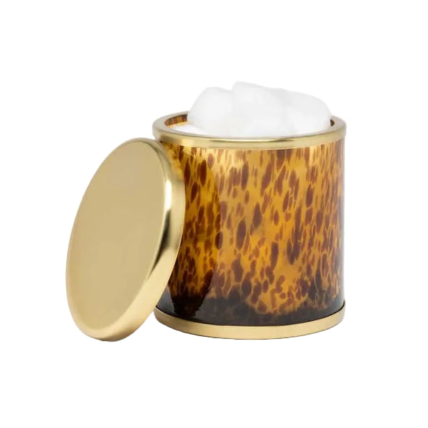 A cylindrical tortoiseshell container from the Benton Tortoise Bath Collection by Pigeon & Poodle holds a white cream or mousse, its gold lid resting to the side—an elegant accent for any bath design.
